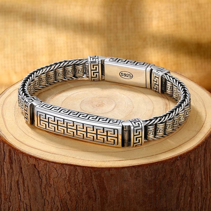 Silbernes Armband mit Griechenmuster am Holzuntergrund getragen elegant