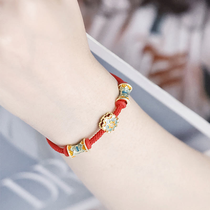 Rotes Armband mit goldenen Lotusperlen am Handgelenk getragen