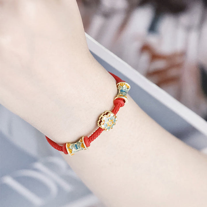 Rotes Armband mit goldenen Lotusperlen am Handgelenk getragen