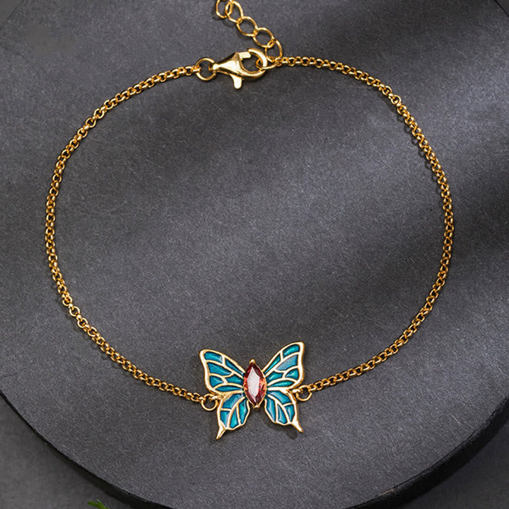 Goldenes Schmetterling Armband mit türkisen Flügeln und rosa Stein