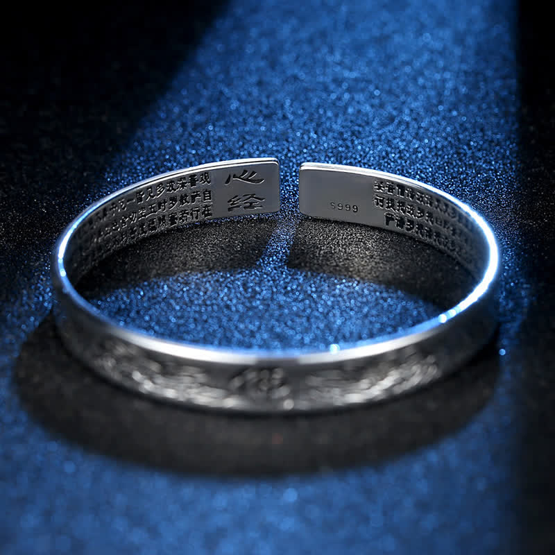Silbernes Armband mit Herzsutra-Gravur auf blauem Glitzer-Hintergrund.