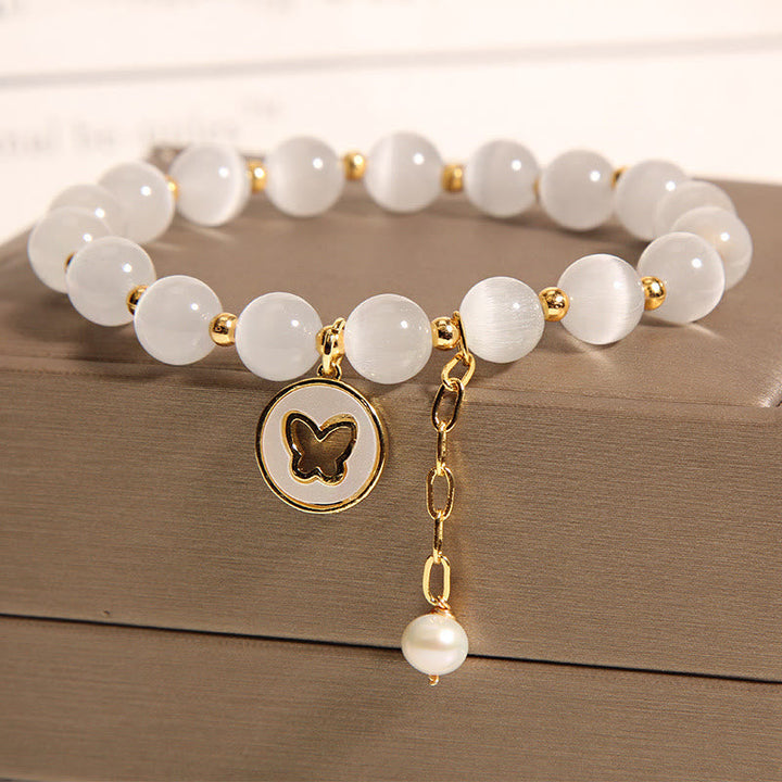 Armband Schmetterling weiße Jade Perlen goldene Akzente elegant.