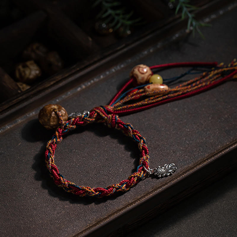 Rotes Armband mit Silberperlen und Koi-Fisch Anhänger elegant präsentiert.