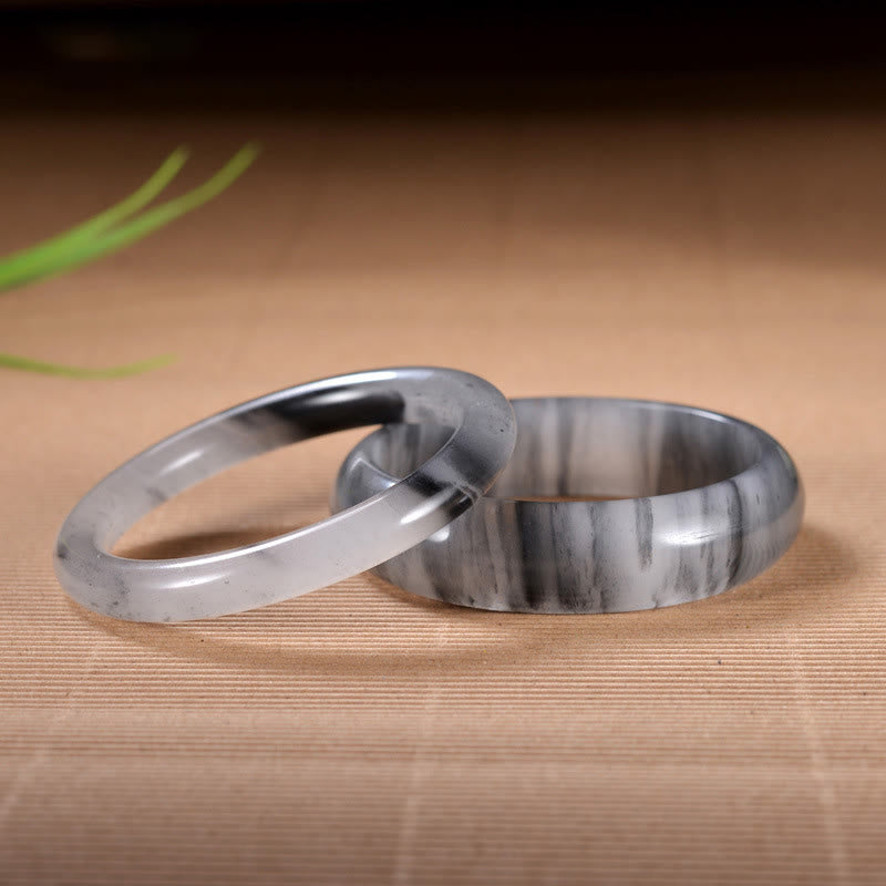 Jade Armband Paar elegante graue Naturstein Ringe Holzuntergrund