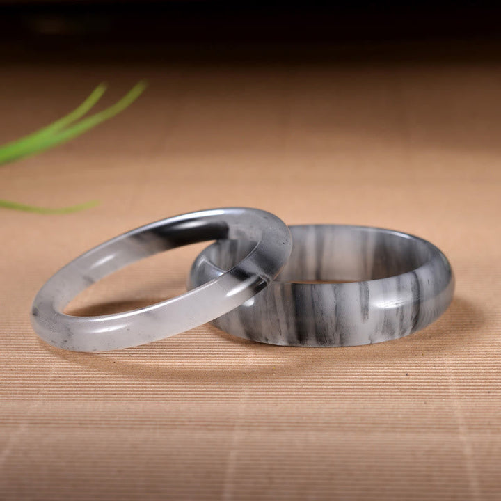 Jade Armband Paar elegante graue Naturstein Ringe Holzuntergrund