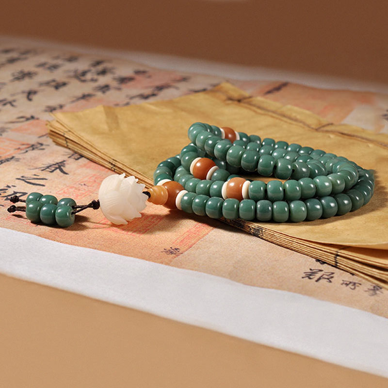 Grünes Bodhi Lotus Armband mit Perlen und weißem Stein elegant präsentiert.