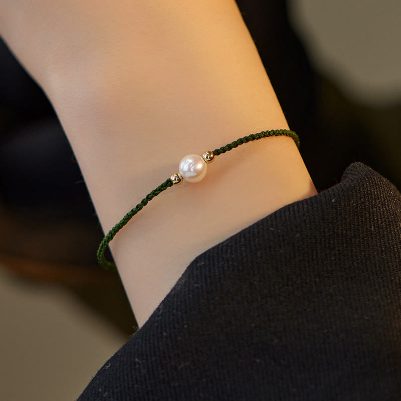 Armband Naturperle Geflochten am Handgelenk grünes Seil weiße Perle getragen