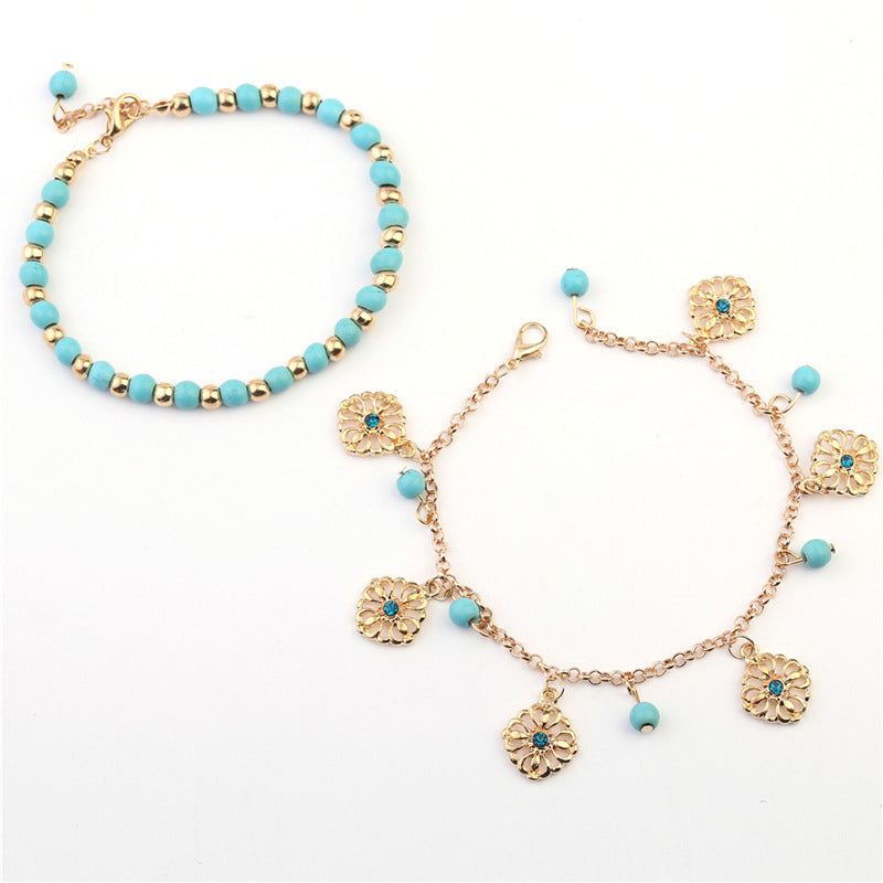 Armband Türkis – Schutz mit goldenen Blütenanhängern und Perlen.