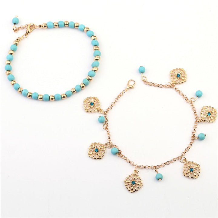 Armband Türkis – Schutz mit goldenen Blütenanhängern und Perlen.