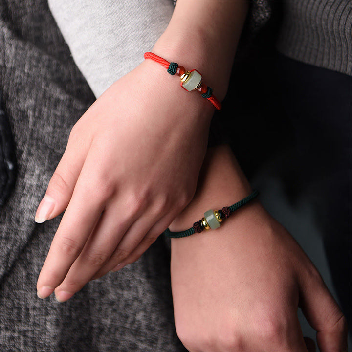 Armband Grüner Aventurin am Handgelenk mit roten schwarzen Schnüren getragen