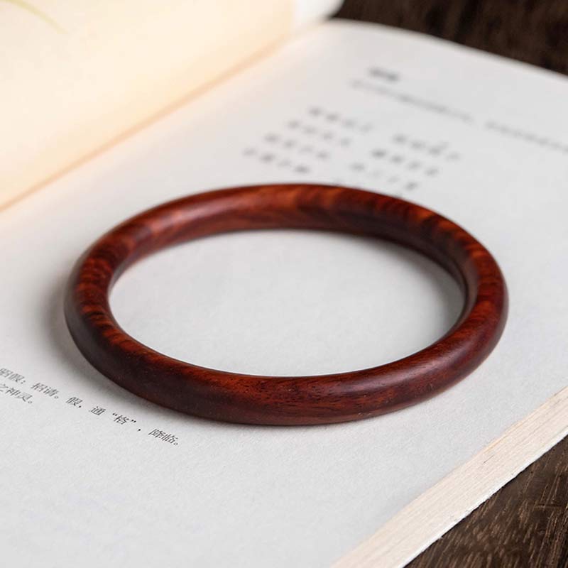 Sandelholz Armband braun auf offener Buchseite, Naturholz Schmuck