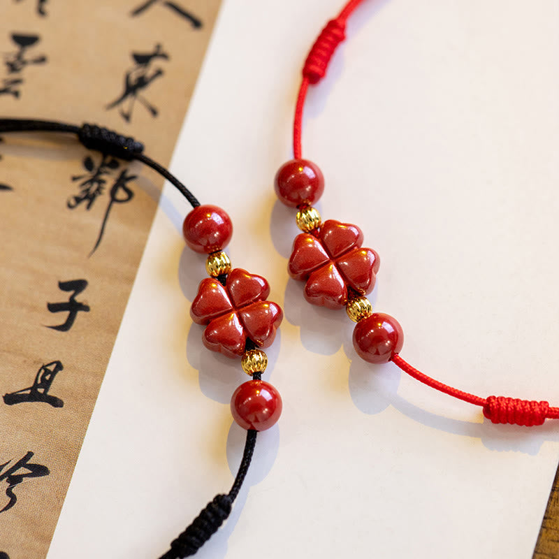 Armband Zinnober Kleeblatt mit roten Perlen, goldenen Elementen, traditionelles Design