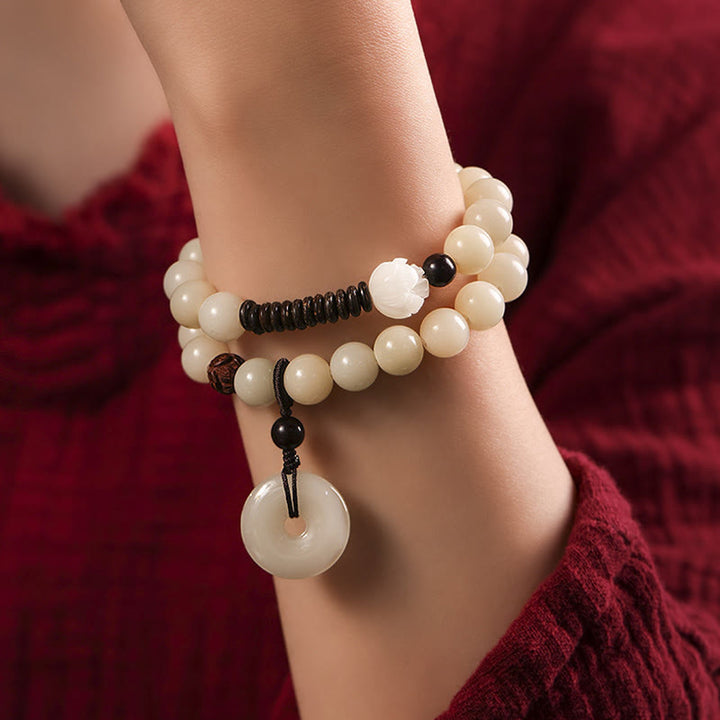 Sandelholz Bodhi Lotus Armband mit weißen Perlen und schwarzer Kordel getragen.