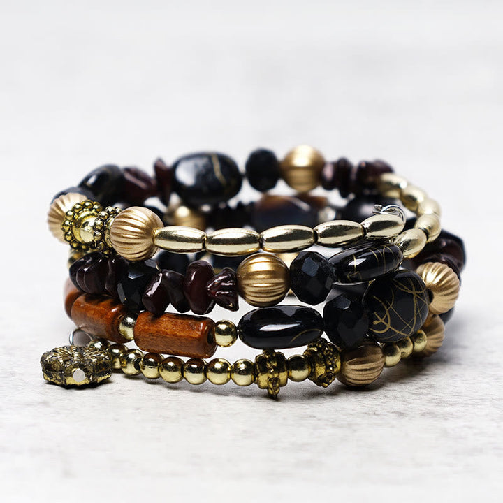 Mehrschichtiges Armband mit schwarzen Steinen und goldenen Perlen Flachansicht