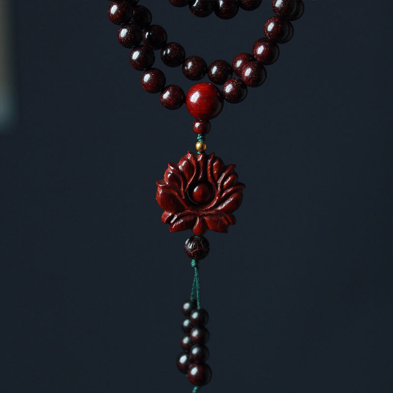 Sandelholz Lotus Armband Balance rote Perlen Blütenanhänger Nahaufnahme