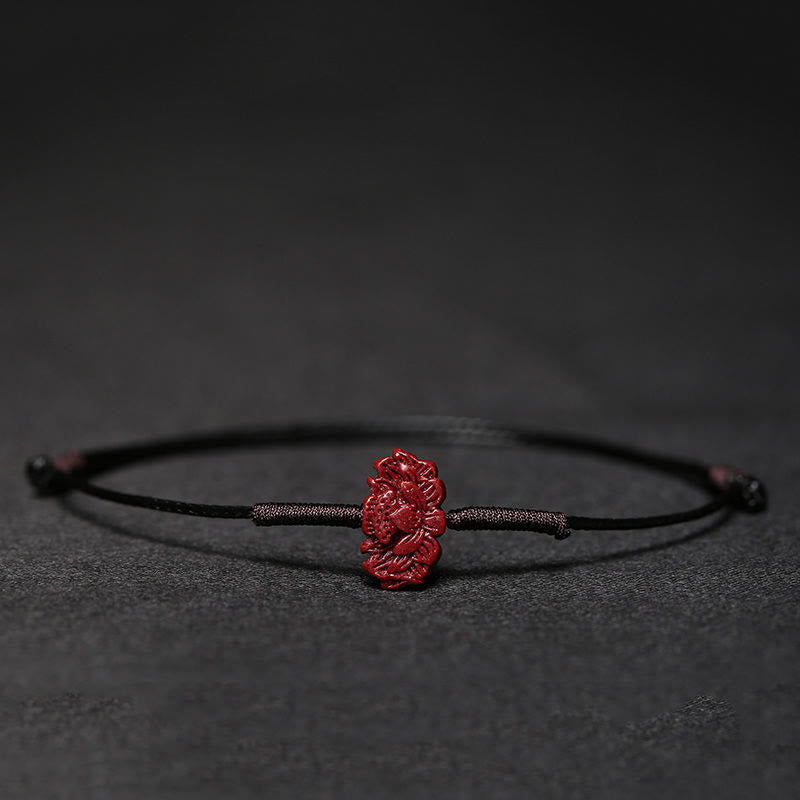 Rotes Zinnober Koi Fisch Armband auf schwarzem Hintergrund Nahaufnahme elastisch