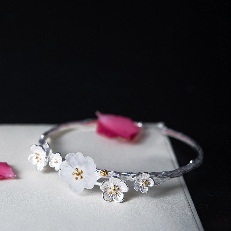 Silberarmband mit weißen Blüten und goldenen Staubgefäßen elegant.