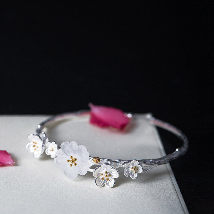 Silberarmband mit weißen Blüten und goldenen Staubgefäßen elegant.