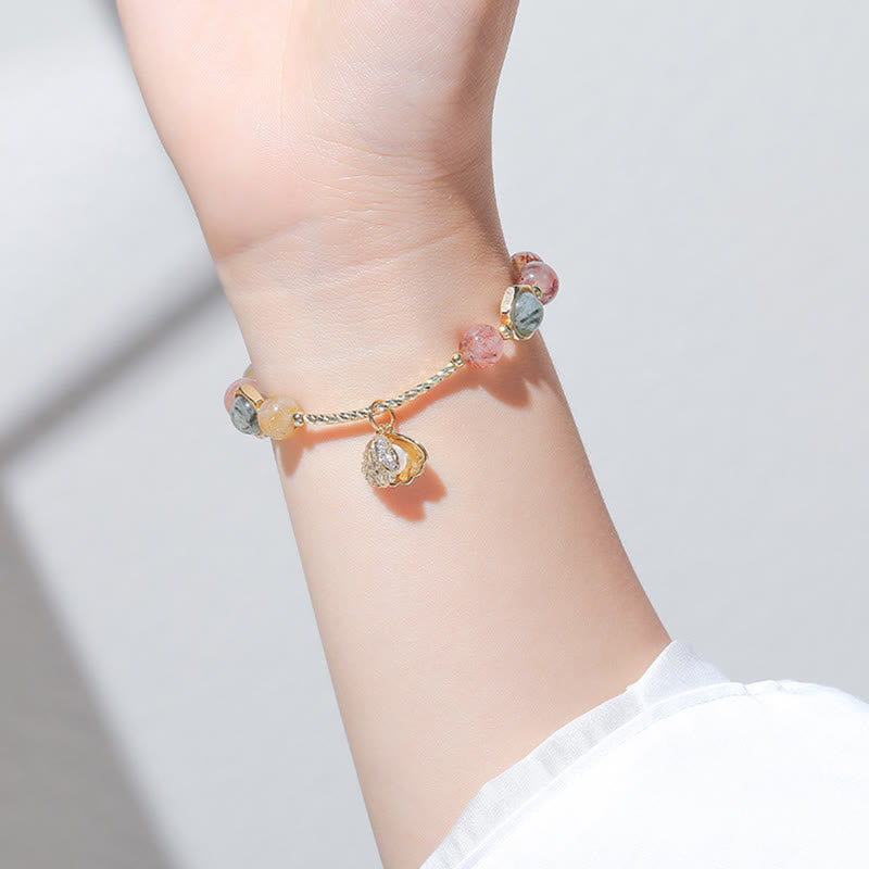 Buntes Armband mit Rutilquarz und Shell Perlen am Handgelenk getragen.