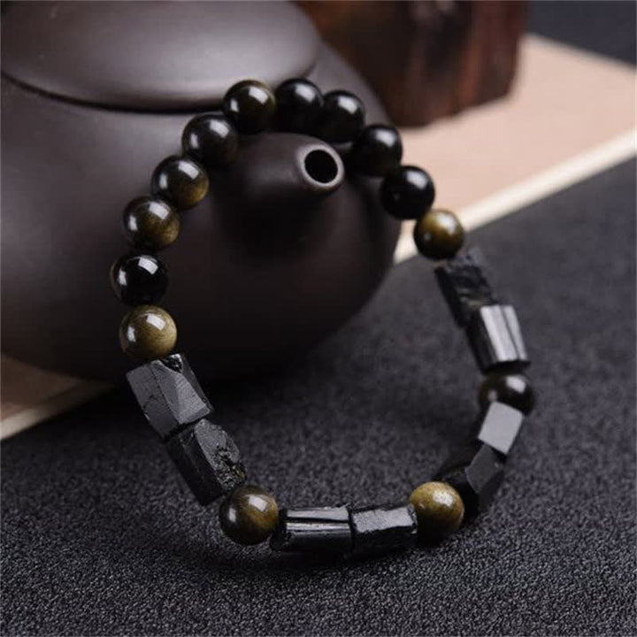 Armband Obsidian mit goldenen Akzenten, schwarze Perlen, elegantes Design auf Tuch
