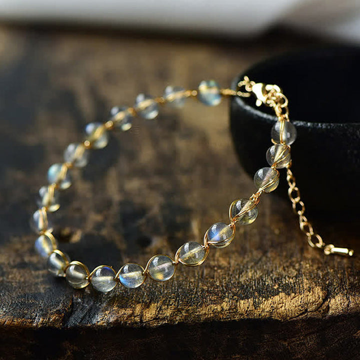 Mondstein Armband Heilung mit goldenem Kettenglied auf Holz Nahaufnahme