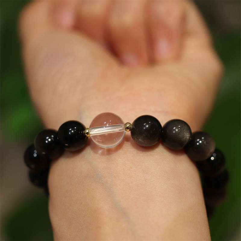 Schwarzes Obsidian Armband mit weißem Kristall Yin Yang am Handgelenk getragen.