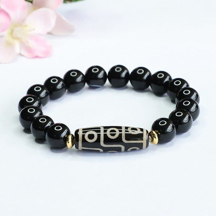 Armband Schwarzer Onyx mit graviertem Mittelteil und goldenen Akzenten elastisch.