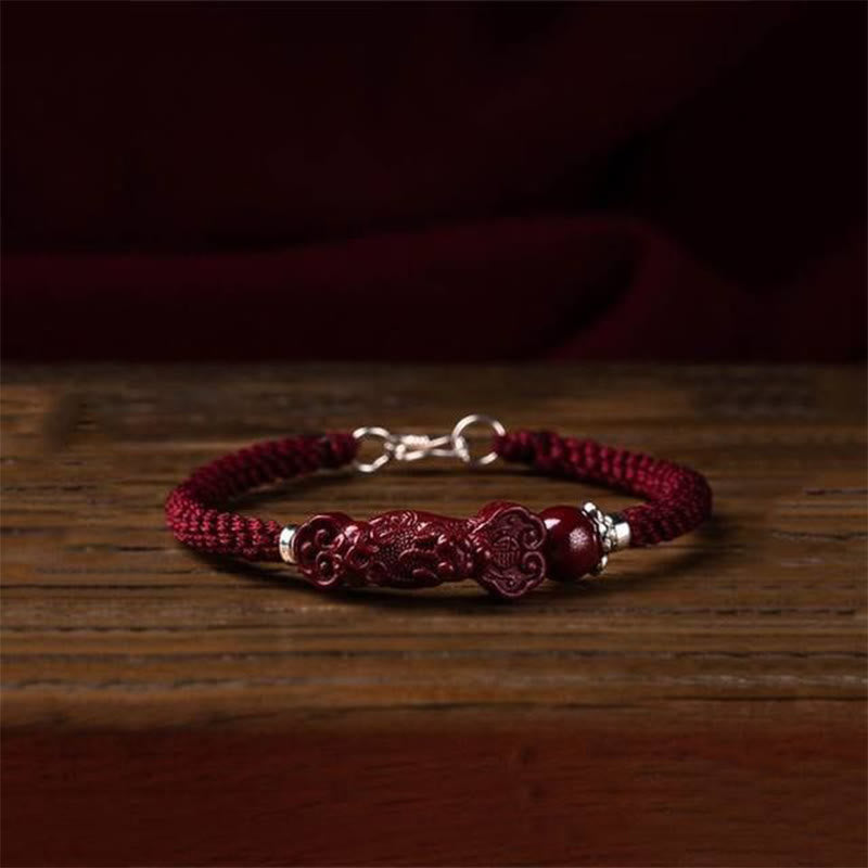 Zinnober Pixiu Armband auf Holz, rotes Textilband mit silbernen Verschlüssen, Glück Wohlstand