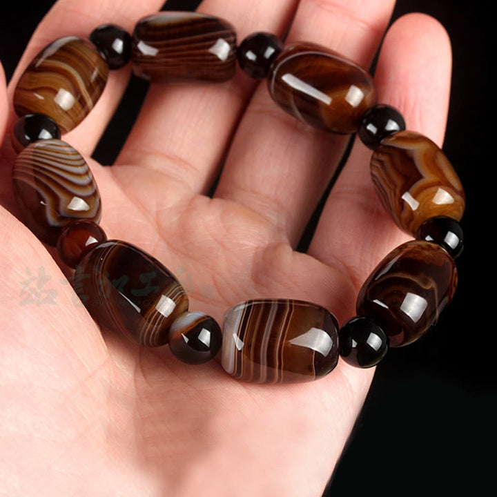 Armband Onyx – Glück & Mut mit braunen Achat Perlen elastisch getragen