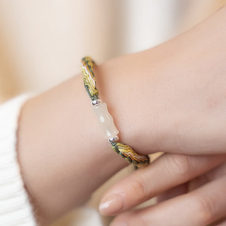 Armband Weiße Jade Bambus am Handgelenk mit grünem Seidenband getragen