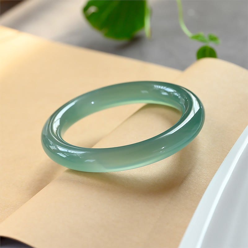 Grünes Chalcedon Armband Armreif auf beiger Oberfläche eleganter Naturstein