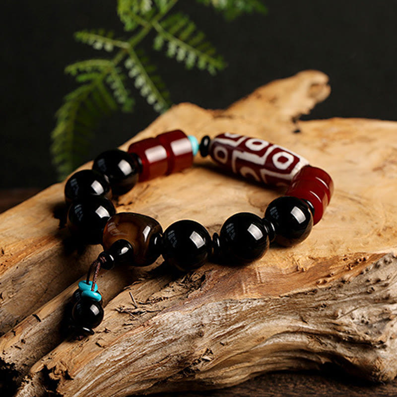 Armband Schwarzer Onyx mit roten Perlen auf Holz natürlich.