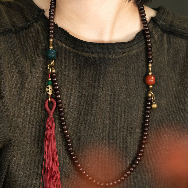 Mala 108 Perlen Bodhi – Stärke Halskette mit roten Quasten tragend