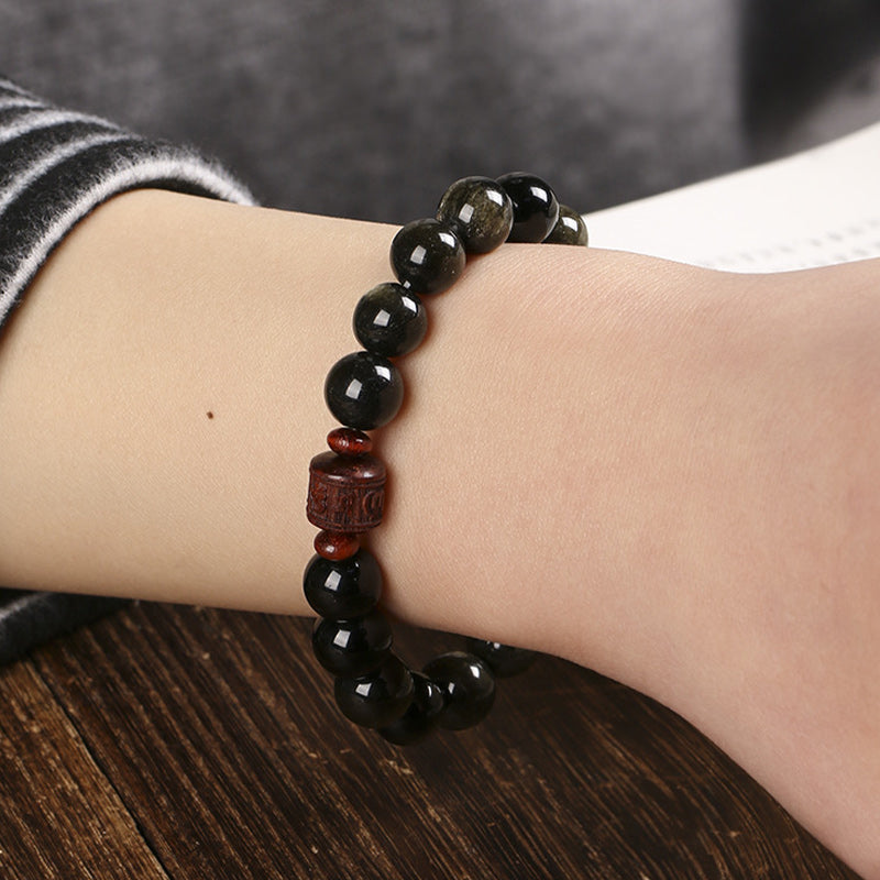 Schwarzes Obsidian Armband mit Om Mani Padme Hum Anhänger am Handgelenk