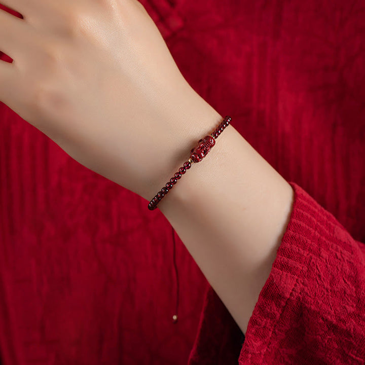 Armband Zinnober Granat Pixiu am Handgelenk rote elegante Perlen