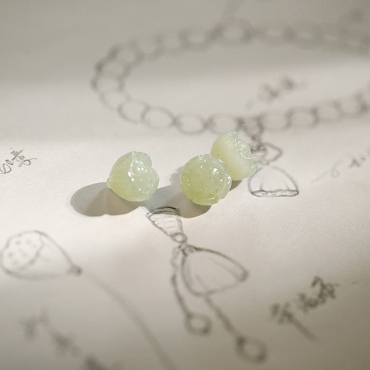 Hellgrünes Jade Lotus Armband mit Natursteinen auf Skizzen.