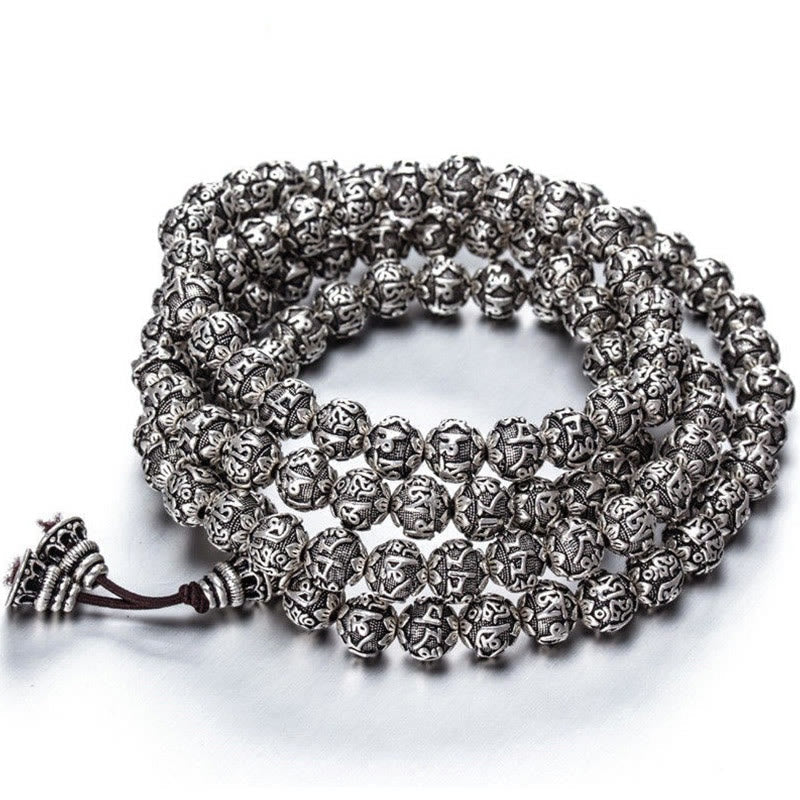 Silbernes Armband Om Mani Padme Hum mit ornamentalen Perlen und Kordel.
