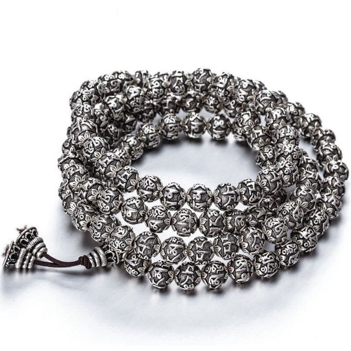 Silbernes Armband Om Mani Padme Hum mit ornamentalen Perlen und Kordel.