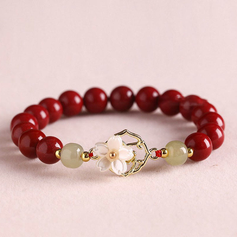 Armband Zinnober Jade – Segen rote Perlen goldene Blütenanhänger elegant