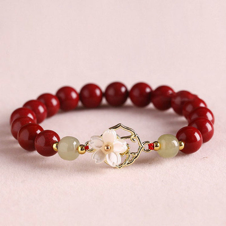 Armband Zinnober Jade – Segen rote Perlen goldene Blütenanhänger elegant