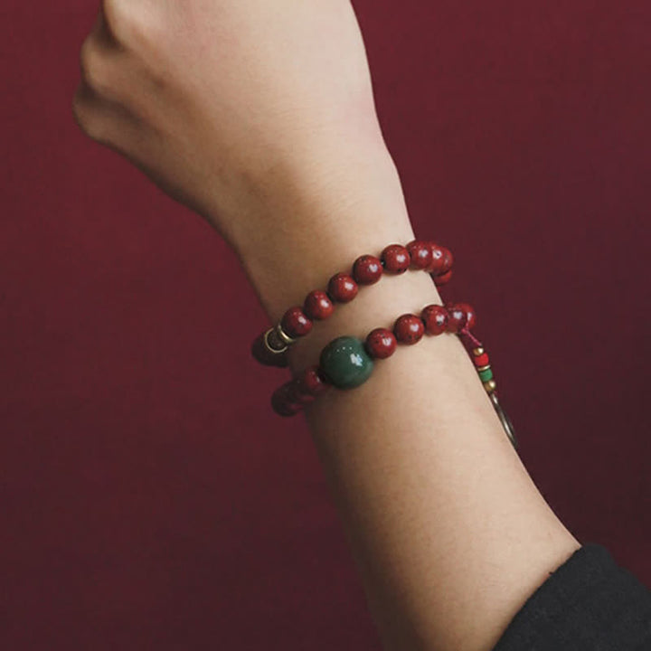 Armband Cyan Jade Kupfer am Handgelenk mit roten Perlen getragen.