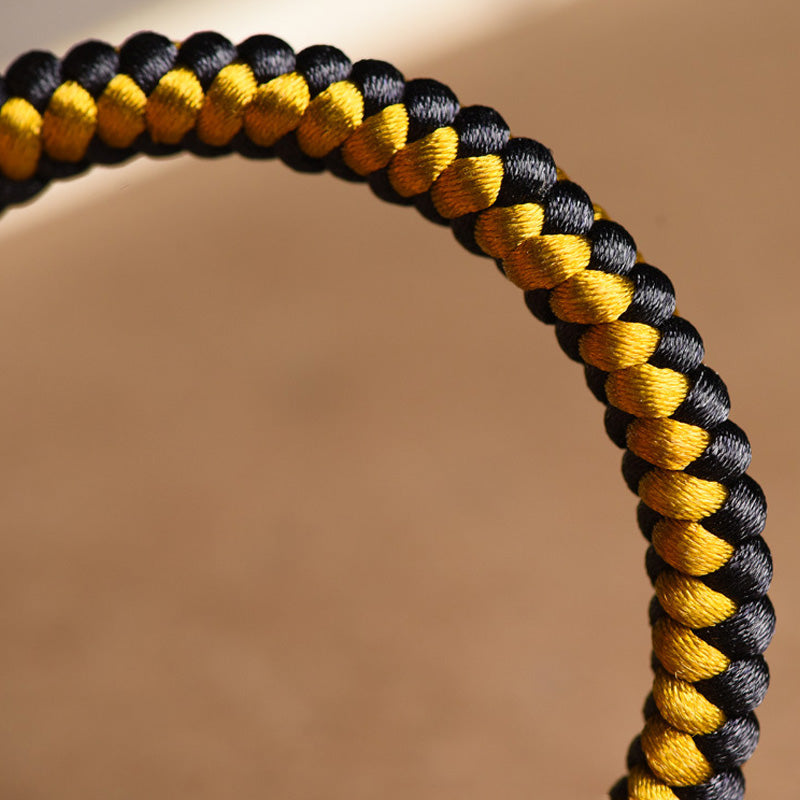 Armband Om Mani Padme Hum Gold schwarzgelb geflochten Nahaufnahme Detail