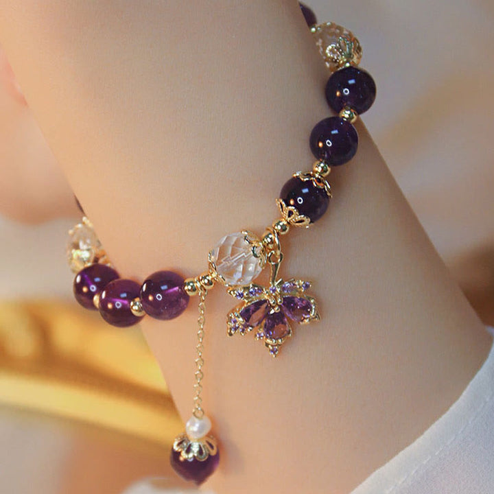 Armband Amethyst mit violetten Steinen und goldfarbenen Verzierungen am Handgelenk