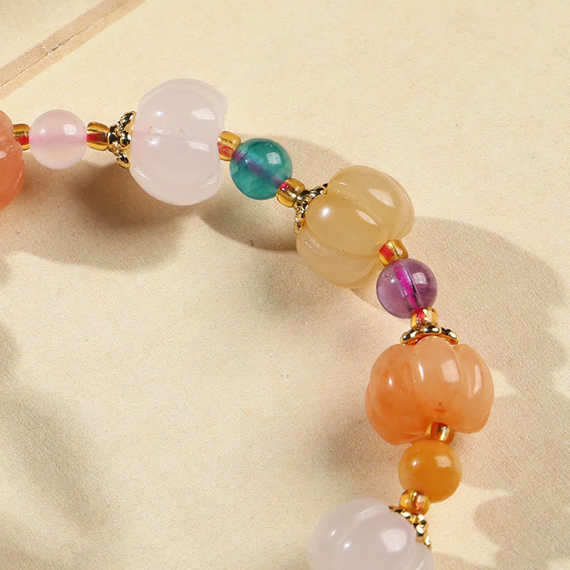 Buntes Kristall Armband mit Jade und Edelsteinen auf Stoff.