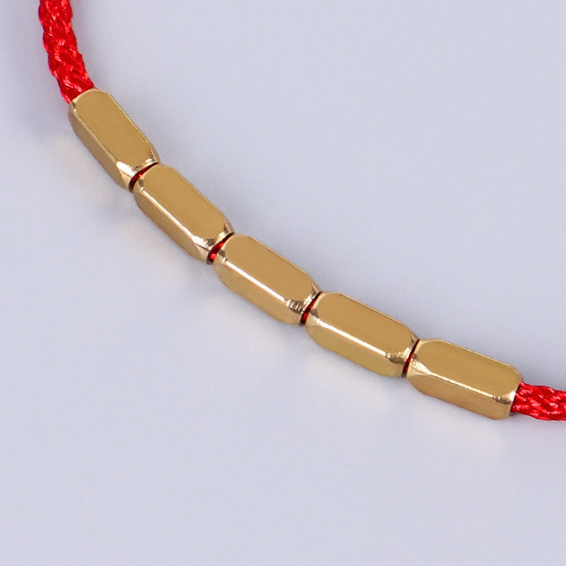 Goldenes Armband mit roten Kordel Kupfer Schutz elegant.