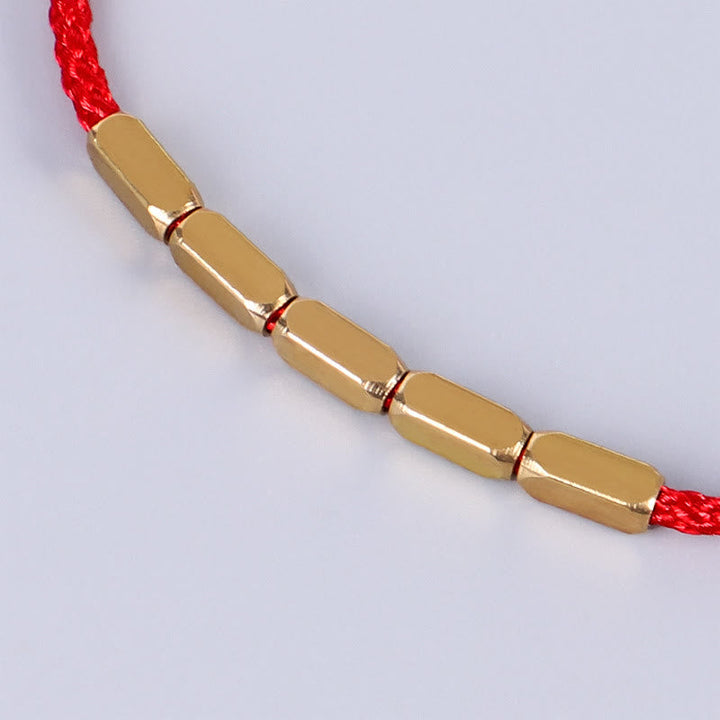 Goldenes Armband mit roten Kordel Kupfer Schutz elegant.