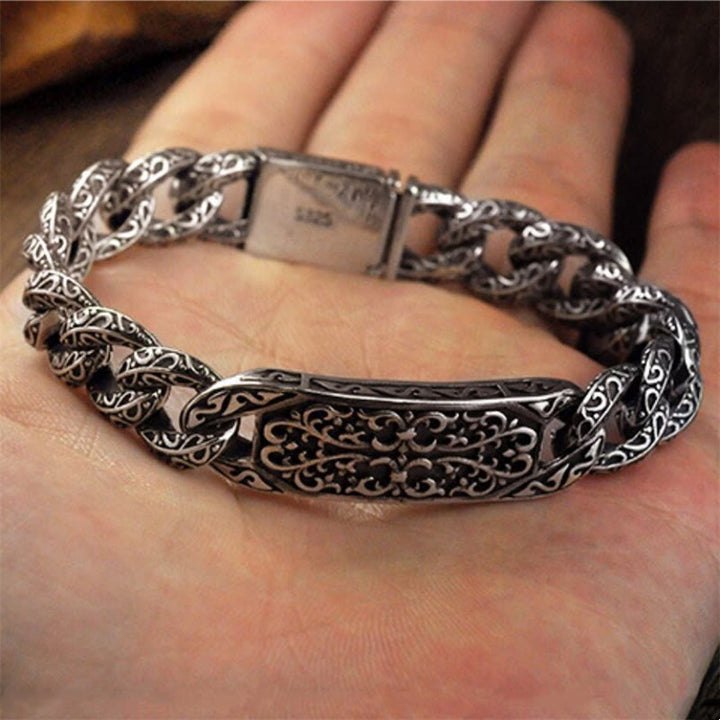 Silbernes Armband mit Drachen-Gravur am Handgelenk getragen