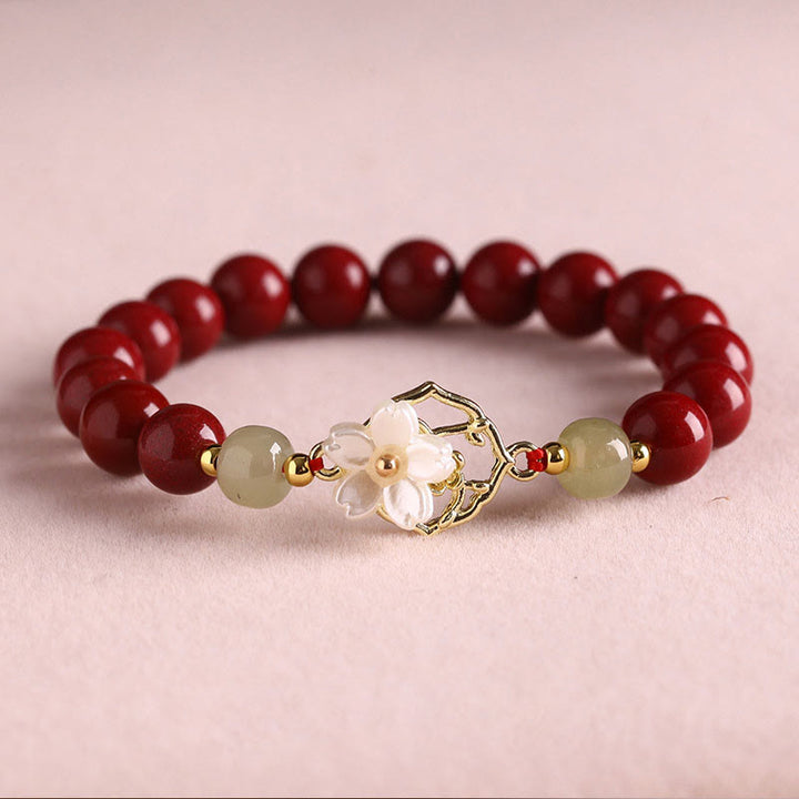 Armband Zinnober Jade – Segen mit goldenem Blütenanhänger elegant.