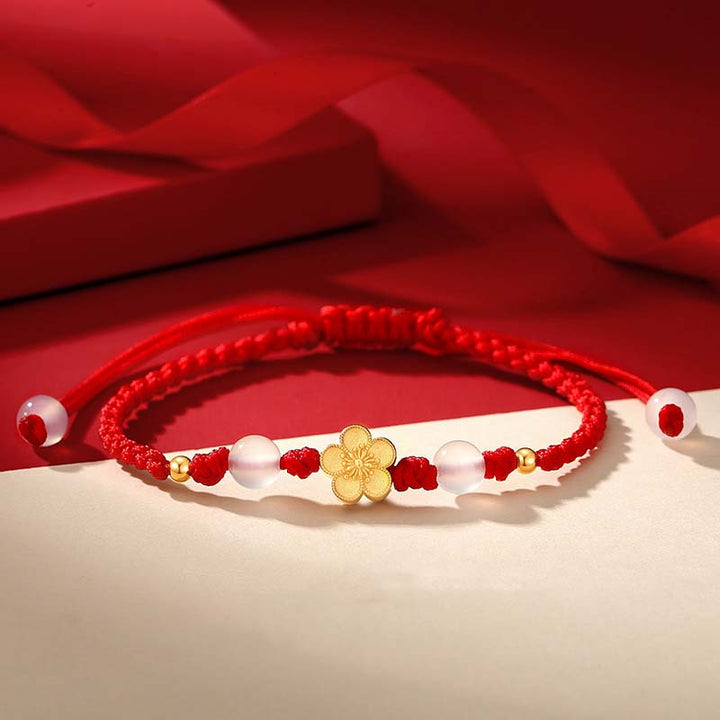 Rotes Armband mit Pfirsichblüte Charm und Perlen elegant.
