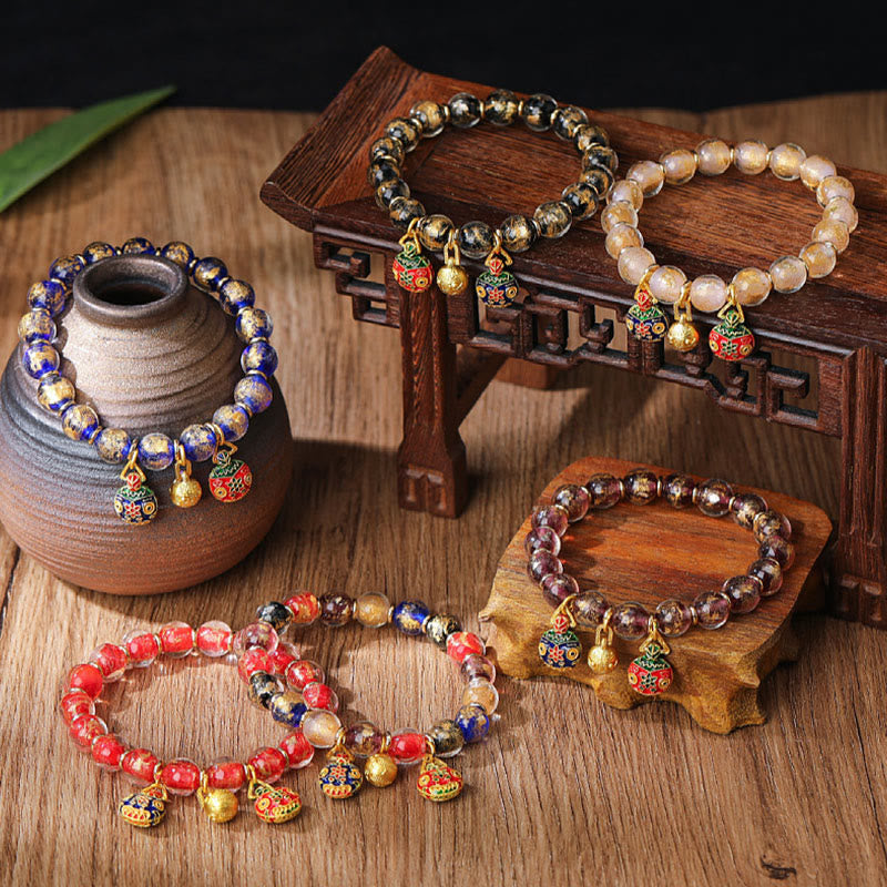 Mehrfarbige Perlenarmbänder mit Anhängern auf Holzoberfläche elegante Schmuckkollektion.